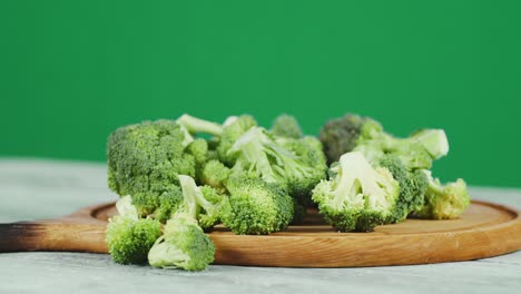 rotating fresh broccoli on a cutting board.