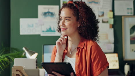 a woman with curly hair is using a tablet in her office