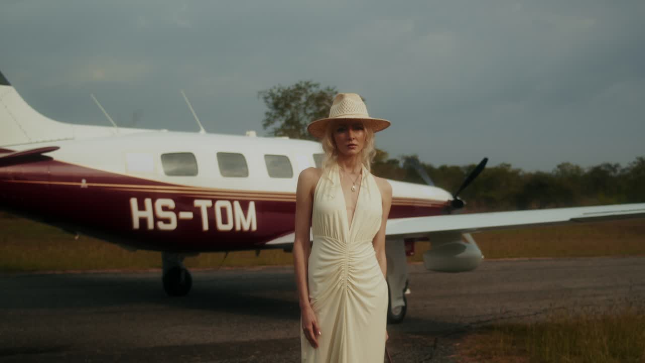 Woman in a dress at an airport with a private jet