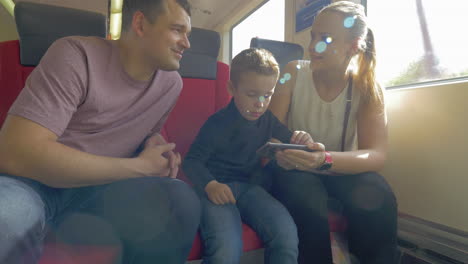 family with child traveling by train and using cell