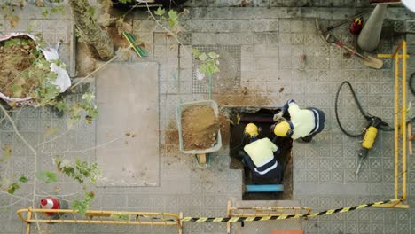 top view of constructor workers digging shoveling and breaking a concrete on a street in barcelona