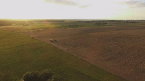 Tractores-De-Maquinaria-Agrícola-Pesada-Con-Implementos-En-Campos-Agrícolas-En-Una-Soleada-Tarde-De-Verano