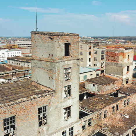 damaged buildings with broken windows and pitted roof outside. abandoned place with empty houses after military actions. aerial view.
