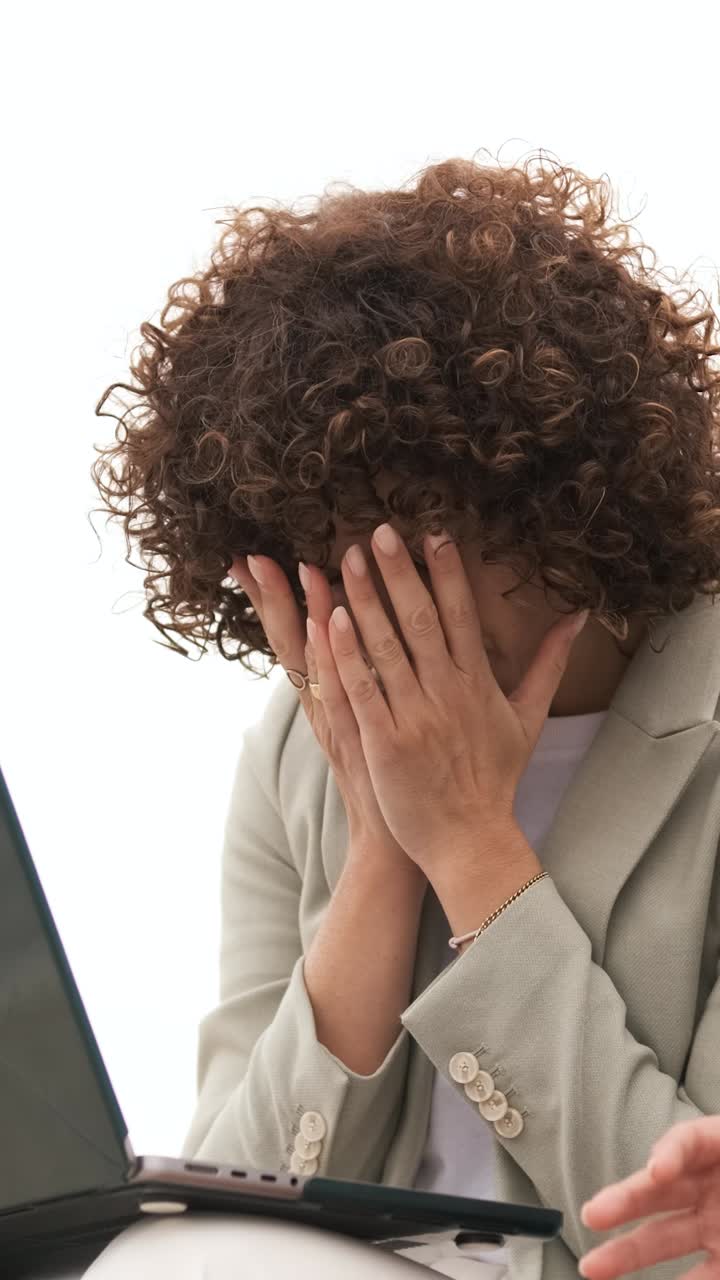 Businesswoman experiencing stress working on laptop. Vertical