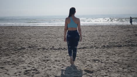 mujer caminando en la playa