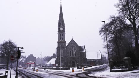 tráfico que pasa por la iglesia de manofield en una tormenta de nieve