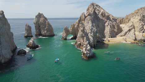 aerial: the arch of cabo san lucas popular tourist destination, pull-away reveal