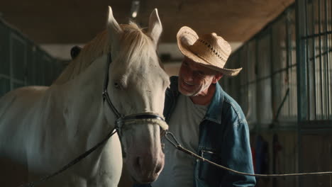 senior man caring for his white horse