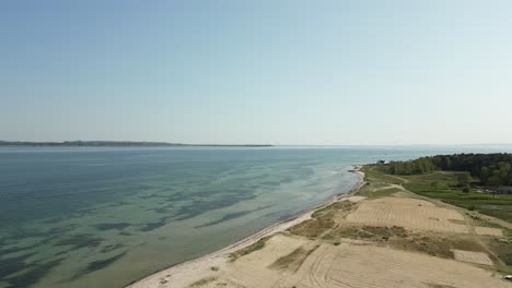 Drone-recording-of-the-beach-coastline,-where-the-drone-has-the-water-on-the-left-side-of-the-image