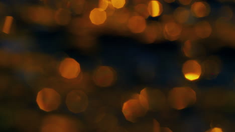 abstract blurred lights sparking on water surface at golden sunrise. sun light