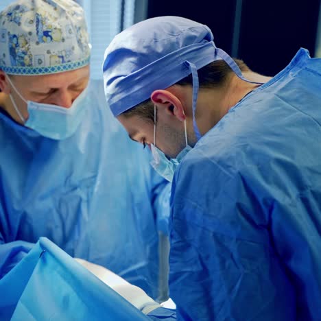 surgical work in the operating room. doctors in blue uniform conduct an operation on a patient . medical specialists saving patient's life in clinic.