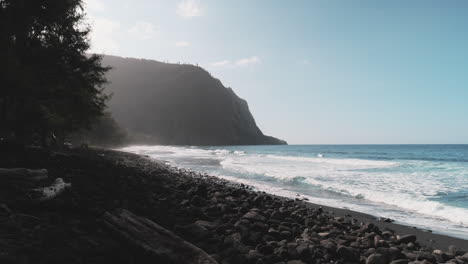 藍色的太平洋海浪在黑色的沙灘上破裂