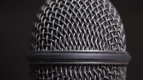 Extreme closeup of old dirty stereo microphone head, spinning. Macro shot.  Scene K.
