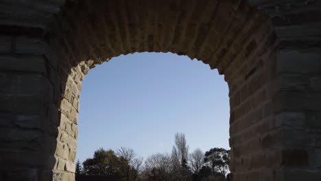 Sandal-Castle-ruins-archway-against-blue-sky-and-tree-background-medium-shot