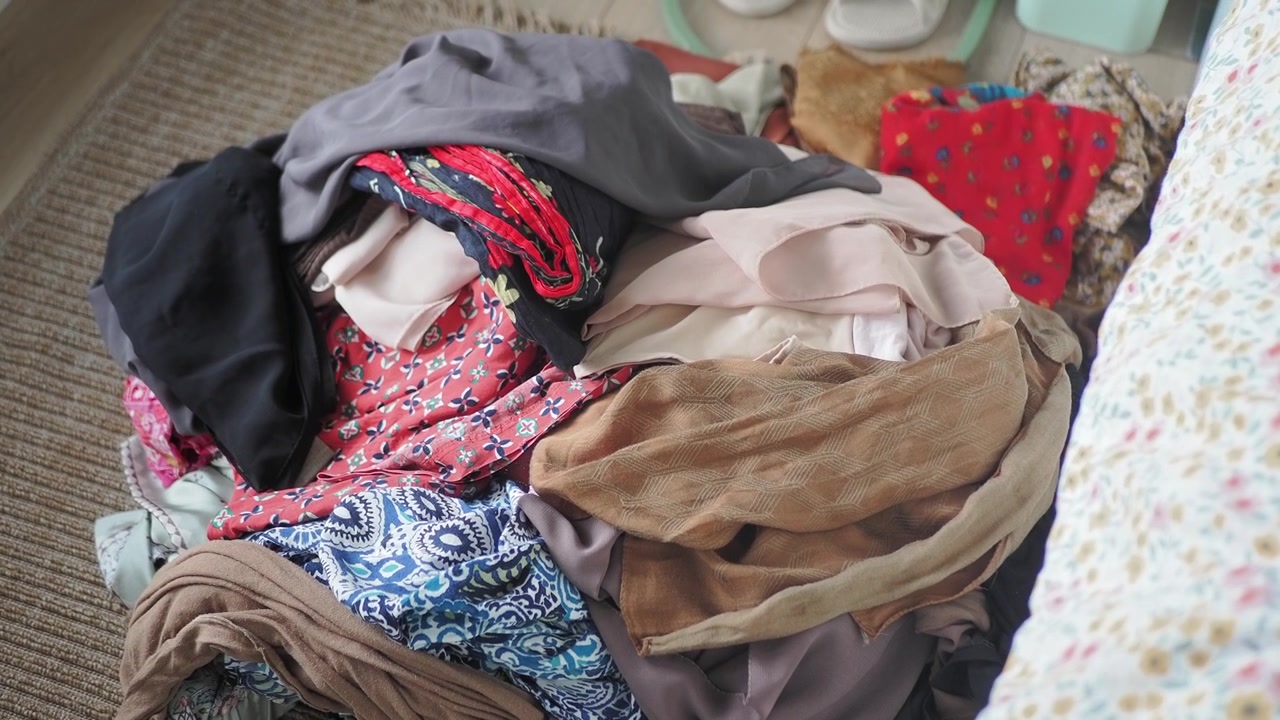 Pila disordinata di vestiti sul pavimento in una camera da letto