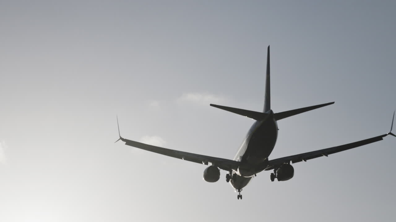 Avión volando en el cielo para aterrizar en el aeropuerto a cámara superlenta al atardecer