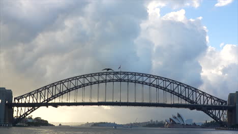 a train passes across sydney harbour bridge on a white cloudy morning in australia