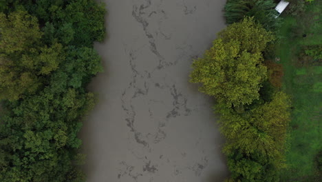 Toma-Aérea-Superior-Sobre-Un-Río-Inundado-Con-Muchos-Sedimentos-En-Montpellier.