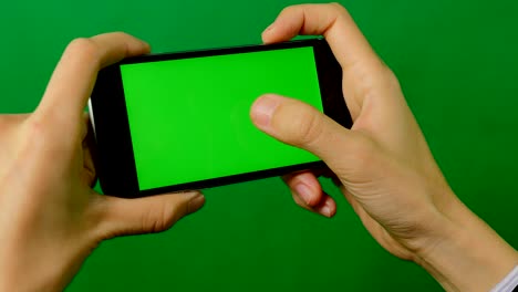 mujer de negocios usando un teléfono móvil de pantalla verde en blanco sobre un fondo verde.