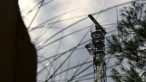 antena de radar militar giratoria observada desde un lugar oculto