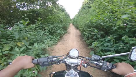 Motociclista-Montando-Campo-A-Través-En-Un-Denso-Callejón-Verde-Montando-A-La-Montaña-En-La-Colina-De-Parasnath-En-Jharkhand,-India