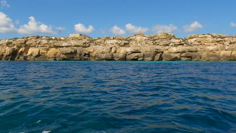 low-angle sea-level view from sailing boat of favignana island and turquoise sea water in sicily, italy