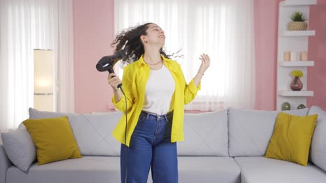 young woman singing and dancing with blow dryer.