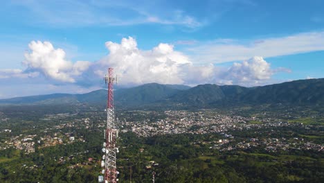 torre de comunicación en la vista aérea de las montañas con la naturaleza y la ciudad en la parte trasera
