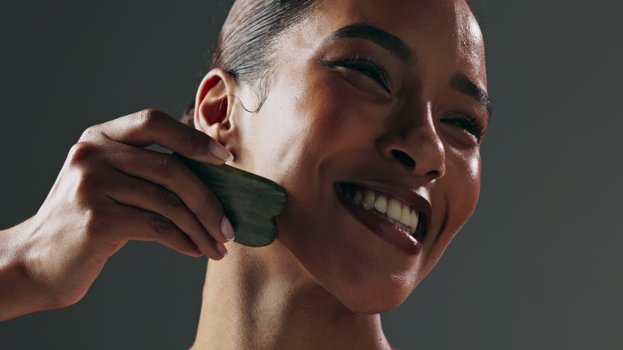mujer recibiendo masaje facial con un rodillo de jade