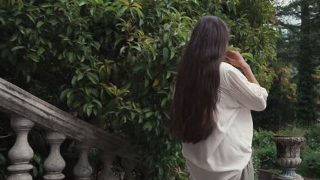 mujer caminando en un jardín histórico