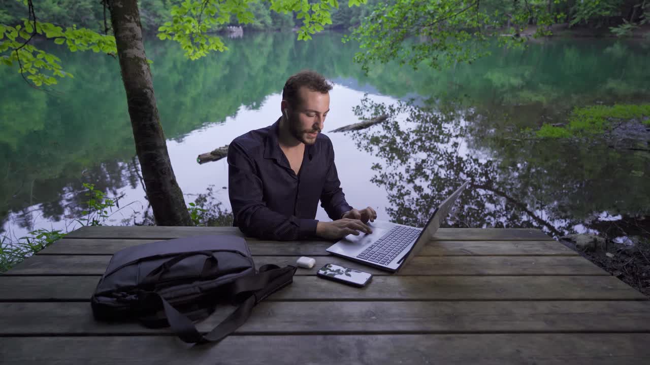 hombre de negocios trabajando con su computadora portátil en un parque natural.