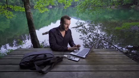 businessman working with his laptop in nature park.