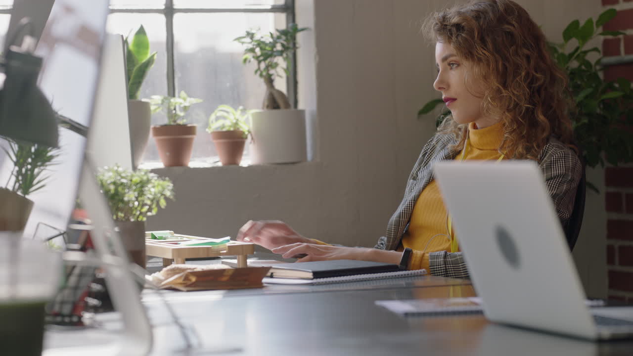 schöne rothaarige geschäftsfrau schreibt mit dem computer, arbeitet brainstorming, kreatives projekt, surft online, informiert sich, vernetzt sich im startup-büro