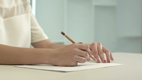 woman with pencil writing on paper