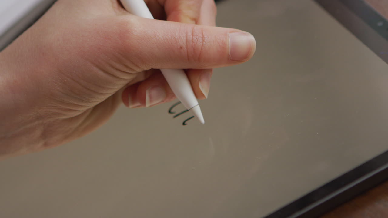 Woman writing on an iPad using a stylus