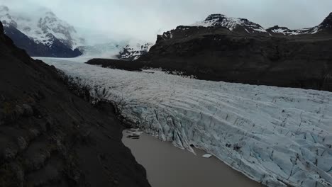 aerial footage over svinafellsjokull showing the glaciers and the giant snow covered mountains in the background-1