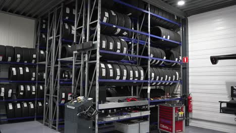 neumáticos de coche en el taller de reparación, pila de neumáticos nuevos en un estante en un almacén mecánico