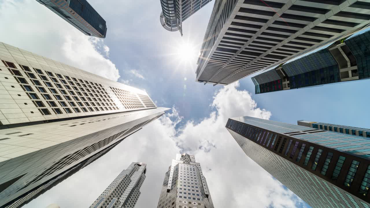 time-lapse de edificios de rascacielos en el distrito comercial de la ciudad de singapur. nube en el cielo de un día soleado. vista de bajo ángulo, zoom out. economía financiera de asia, fusión y adquisición, o concepto de arquitectura moderna