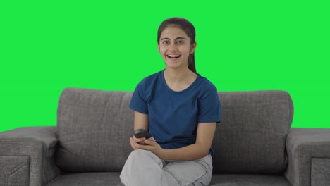 Happy-Indian-teenage-girl-laughing-while-watching-TV-Green-screen