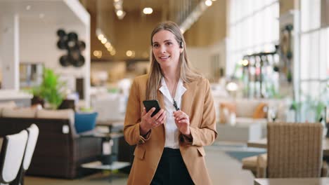 confident associate strolls between displays, smiling down at smartphone