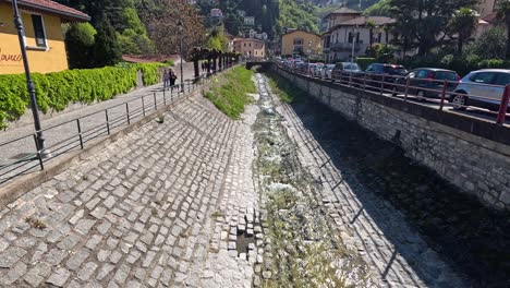 people walking by a stream in varenna