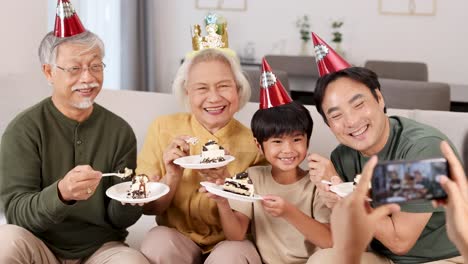 a joyful family celebrates with cake and selfies in a cozy living room, capturing happy moments together