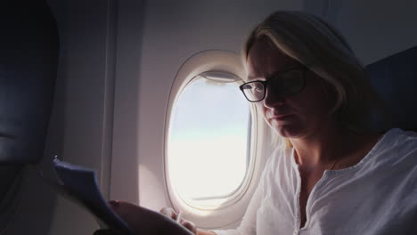 young business woman looks through documents in flight business and travel