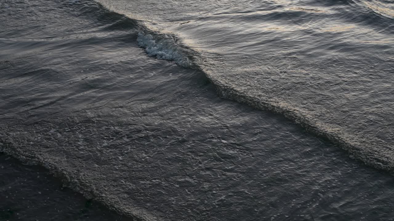 Ocean Waves Calmly Breaking With Blue Hour Light On Surface