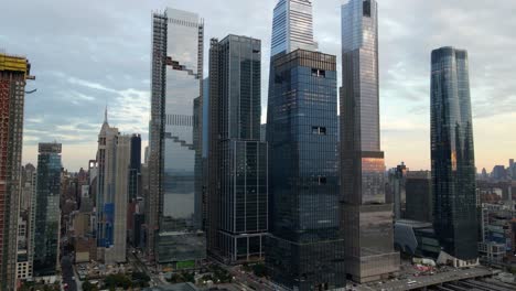 aerial drone view towards tall skyscrapers in hudson yards, sunset in new york, usa