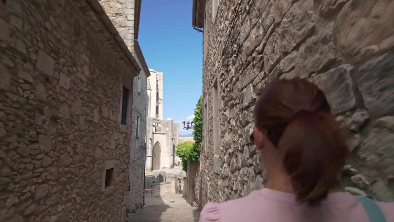 Donna che cammina per le strette vie medievali di Girona