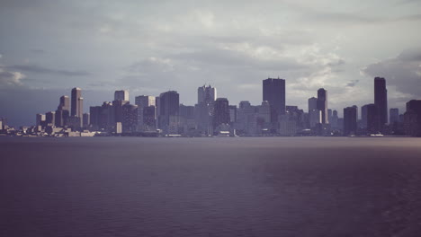 city skyline under a cloudy sky viewed from the water in late afternoon light