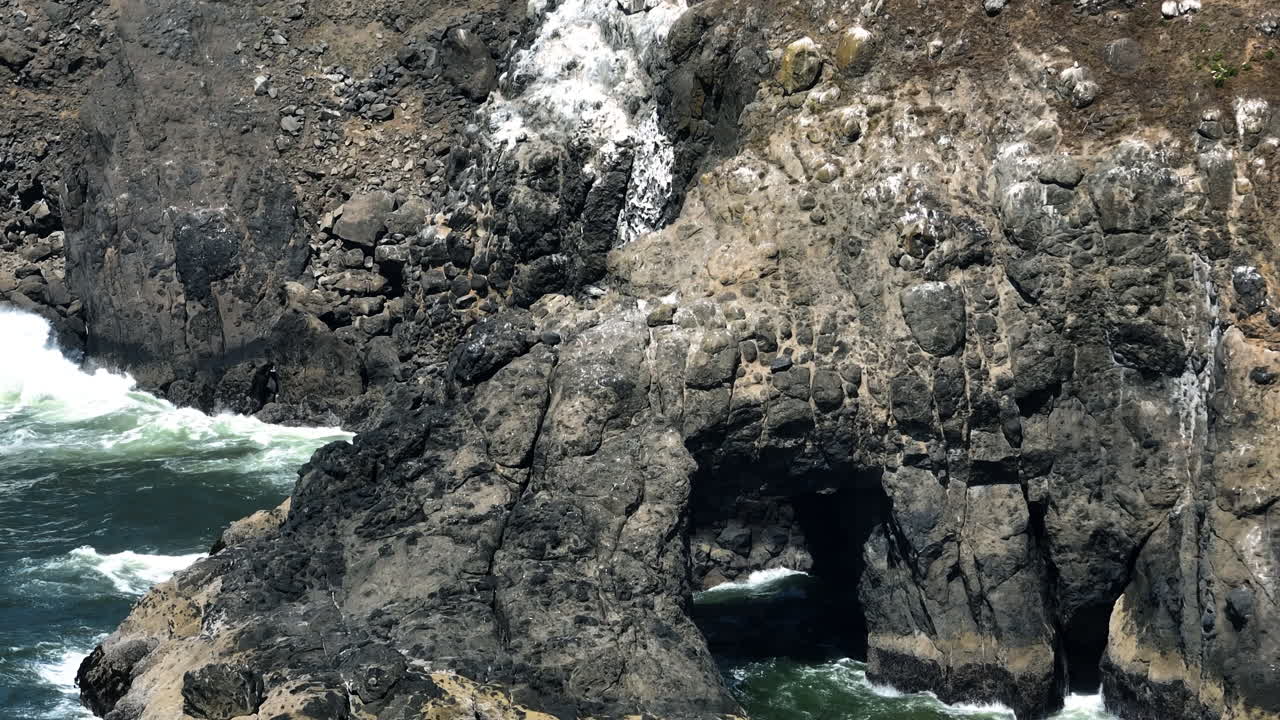 Aerial telezoom of the rocky coast and Heceta head, sunny day in Oregon, USA