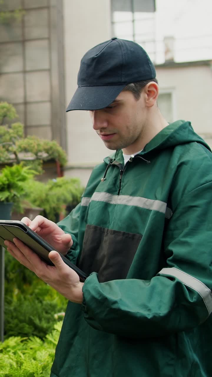 Gardener using a tablet in a garden
