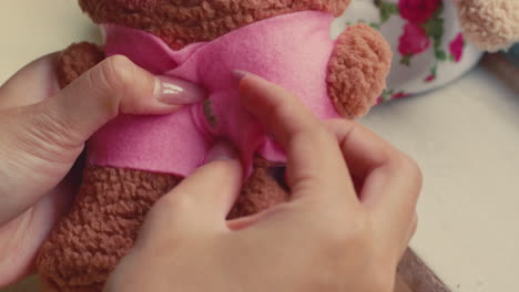sewing a pink outfit for a teddy bear